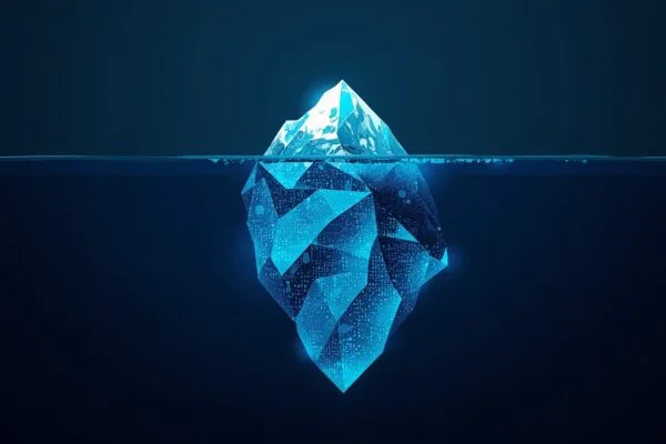 Hidden cost of AI API restrictions concept showing an iceberg where a small visible tip represents the advertised price and a large submerged mass represents the real engineering, monitoring, and usage costs